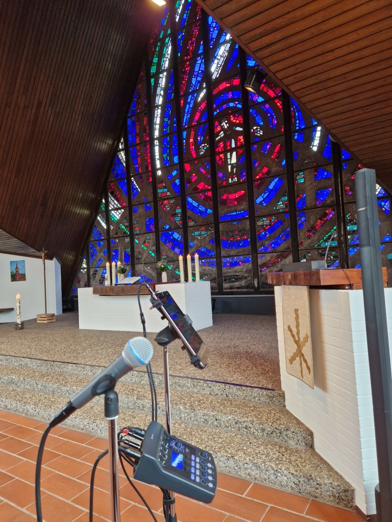 MikrofonTablet und Mischpult vor bunten Kirchenfenstern - der Arbeitsplatz einer Hochzeitssängerin